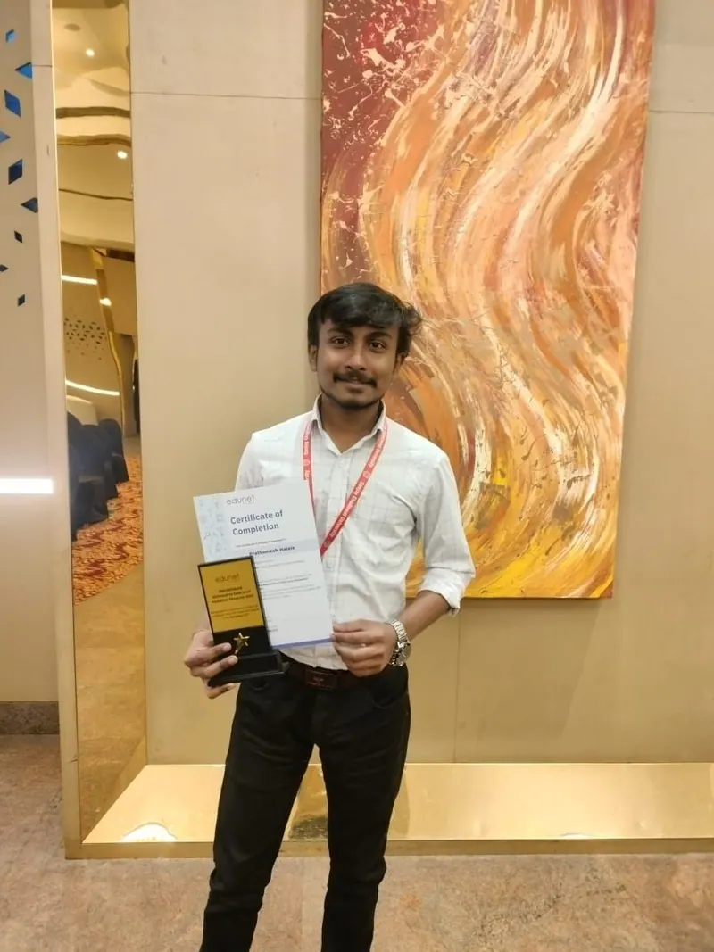 Prathamesh Halale holding the IBM SkillsBuild hackathon trophy and Edunet Foundation certificate